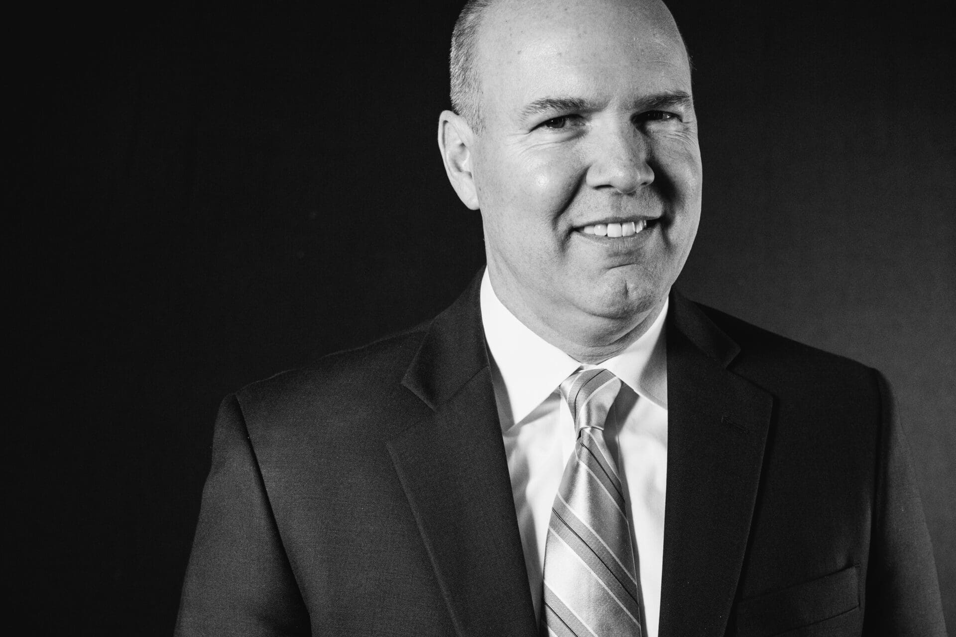 A gray photo of a man wearing a business suit